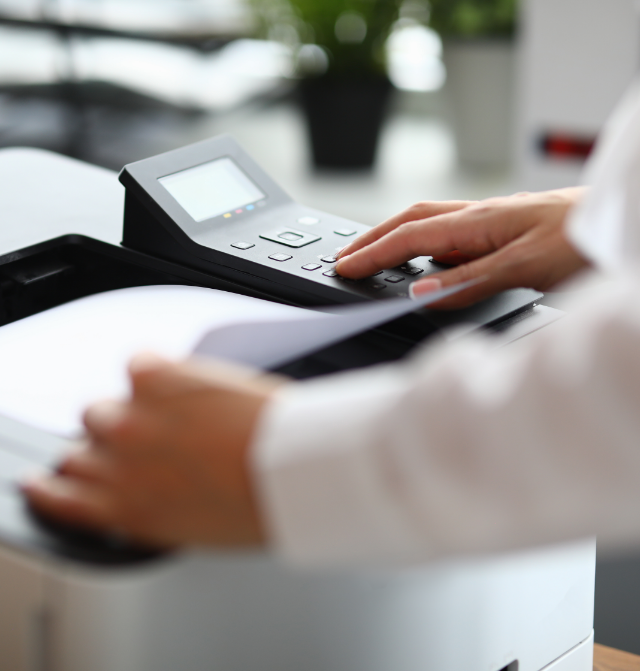 Stampante multifunzione Brother a tre cassetti in un ufficio moderno, con targa 'Noleggio Stampanti' e toner di ricambio.